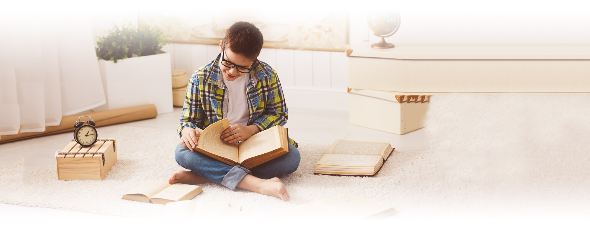 student boy sitting on floor reading book