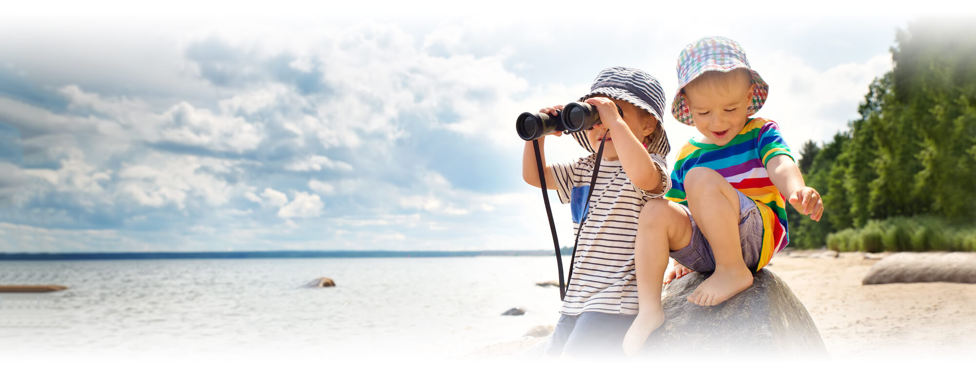 first grade boys on beach using binoculars